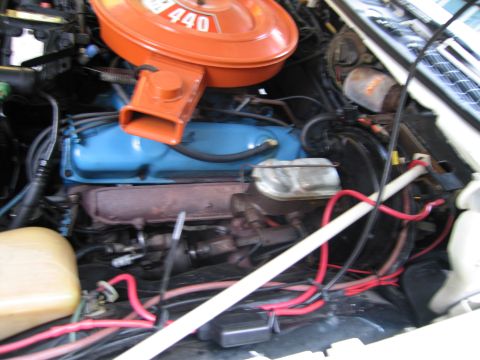 1991 Ford LTD Crown Victoria - Engine bay with an orange round air cleaner labeled 440 mounted on a blue-painted V8 with red battery cables.