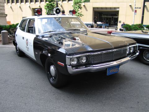 1991 Ford LTD Crown Victoria - black and white vintage Los Angeles Police sedan with dual spotlights and roof lights parked downtown.