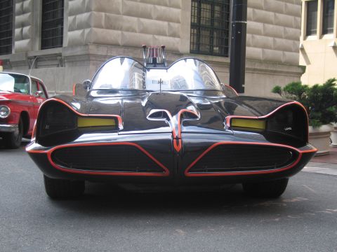 1991 Ford LTD Crown Victoria - Front view of the black Batmobile show car with red pinstripe trim and twin clear bubble canopies on a city street.