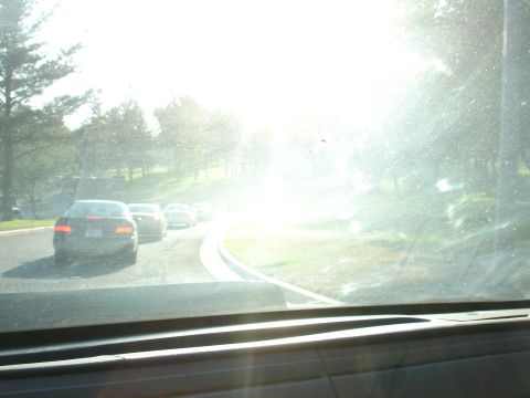 1993 Ford Taurus - Several cars are stopped on a road, with bright sunlight obscuring the view ahead.