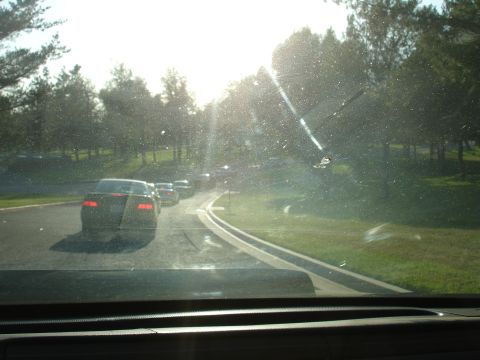 1993 Ford Taurus - Several cars are driving on a road with trees and grass on the side.