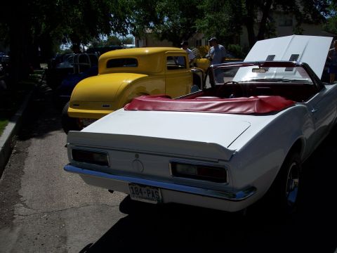 1972 Ford Ranchero - Two classic cars, a white convertible and a yellow coupe, are parked side-by-side on a sunny day.