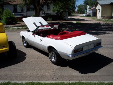 1972 Ford Ranchero - A white convertible with a red interior is parked on a street with its hood open.