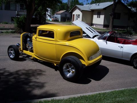 1972 Ford Ranchero - Two classic cars, a yellow hot rod coupe and a white convertible, parked on a street.