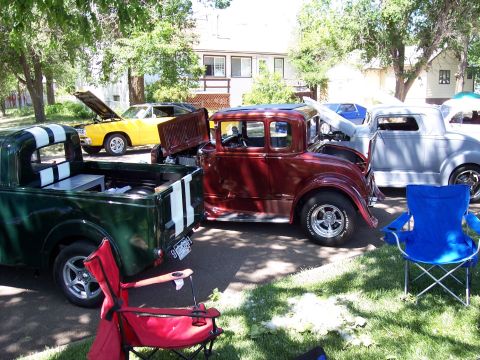 1972 Ford Ranchero - Multiple custom cars are displayed at an outdoor event, with chairs set up nearby.