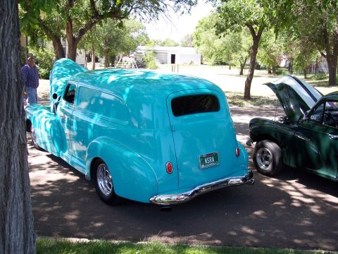 1972 Ford Ranchero - A turquoise panel van is parked next to a green car, both with hoods open at an outdoor car show.