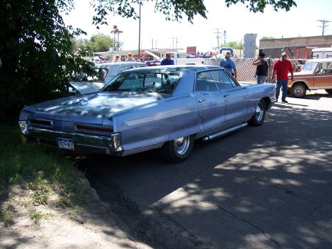 1972 Ford Ranchero - A light blue sedan is parked at an outdoor event with other vehicles visible in the background.