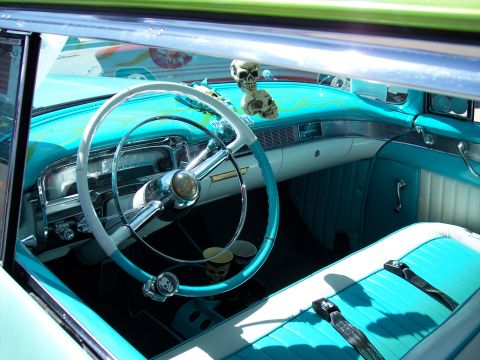 1972 Ford Ranchero - Customized interior of a car with turquoise and white upholstery, a unique steering wheel and skull decorations.