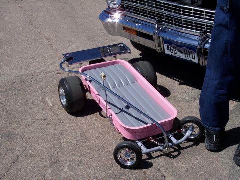 1972 Ford Ranchero - A custom pink wagon with chrome accents sits on pavement next to a car.