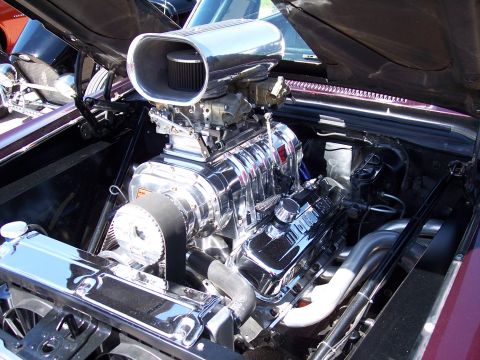 1972 Ford Ranchero - A highly customized engine with a prominent supercharger is displayed under the hood of a vehicle.