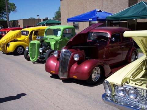 1972 Ford Ranchero - Several custom cars are lined up at an outdoor event under tents.