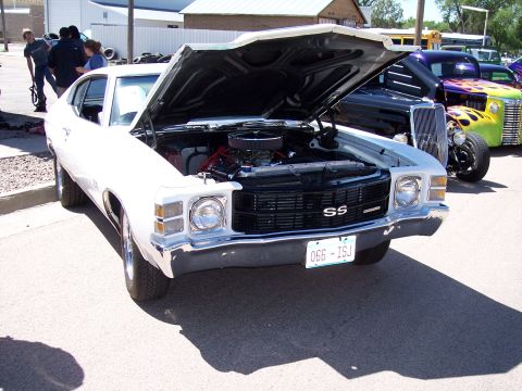 1972 Ford Ranchero - A white 1970 Chevrolet Chevelle SS is displayed with its hood open, revealing the engine, at an outdoor car show.