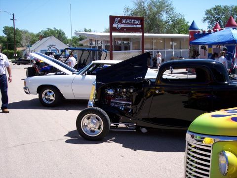 1972 Ford Ranchero - Several custom cars are parked outside a building with a sign for K Electric Association Inc.