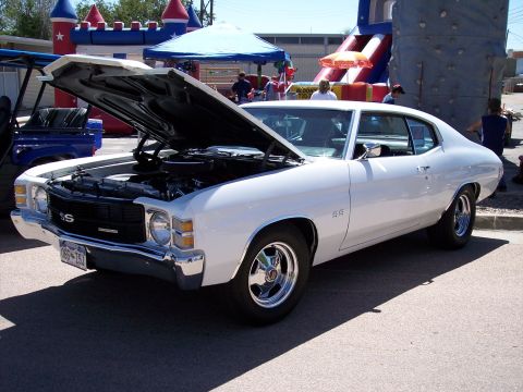 1972 Ford Ranchero - A white coupe with its hood open, displaying SS badging and chrome wheels at an outdoor event.
