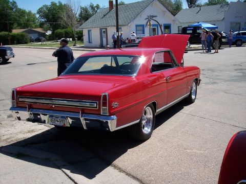 1972 Ford Ranchero - A red coupe is parked at an outdoor event with its hood open.