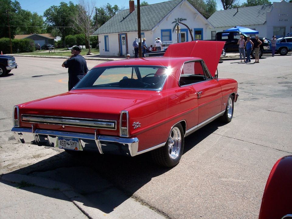 Red coupe with hood open, chrome bumper, and license plate 468-HYD