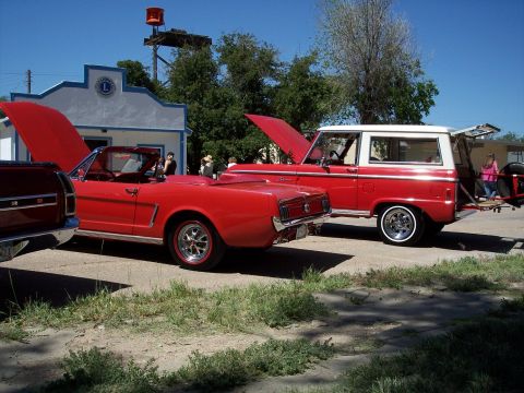 1972 Ford Ranchero - A red 1965 Ford Mustang convertible and a red Ford Bronco SUV are parked side-by-side.