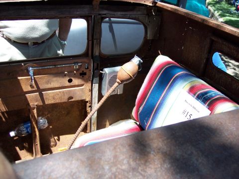 1972 Ford Ranchero - A close-up view of the interior of a weathered vehicle, blankets and a bottle of water.