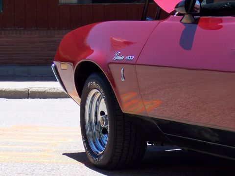 1972 Ford Ranchero - Close-up of a red Ford Ranchero 500, highlighting its side profile and wheel detail.