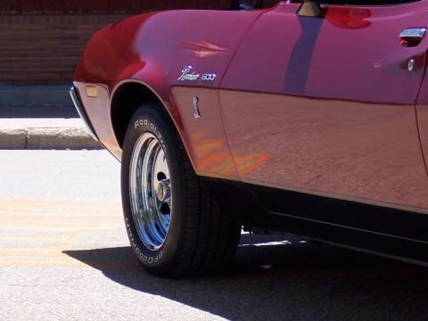 1972 Ford Ranchero - A red car with flame decals on the side panel and a chrome wheel is visible.