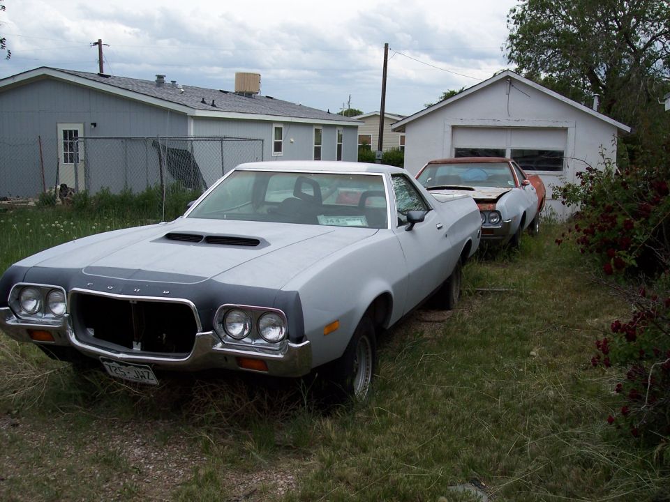 Light gray 1972 Ford Ranchero with black hood accent, parked next to another vehicle