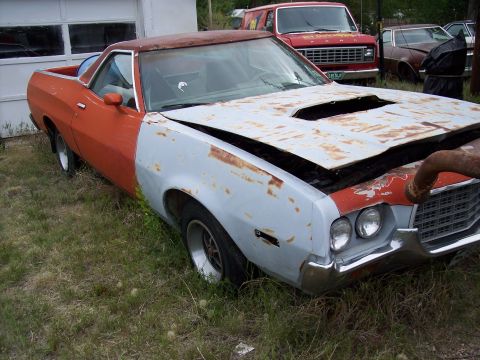 1972 Ford Ranchero - This 1972 Ford Ranchero shows significant rust and primer, with its hood ajar.