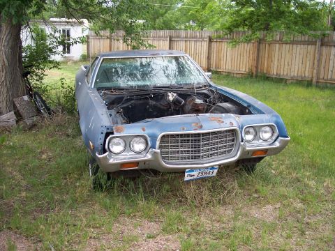 1972 Ford Ranchero - This 1972 Ford Ranchero is in a yard with the hood open, revealing its engine bay.