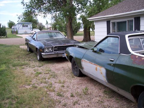 1972 Ford Ranchero - Two Ford Rancheros are parked outside a house, one in front of the other.
