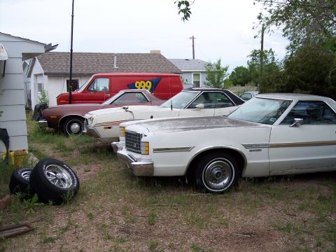 1972 Ford Ranchero - A white 1972 Ford Ranchero is parked in a lot with other vehicles, showing its distinctive body style and chrome accents.