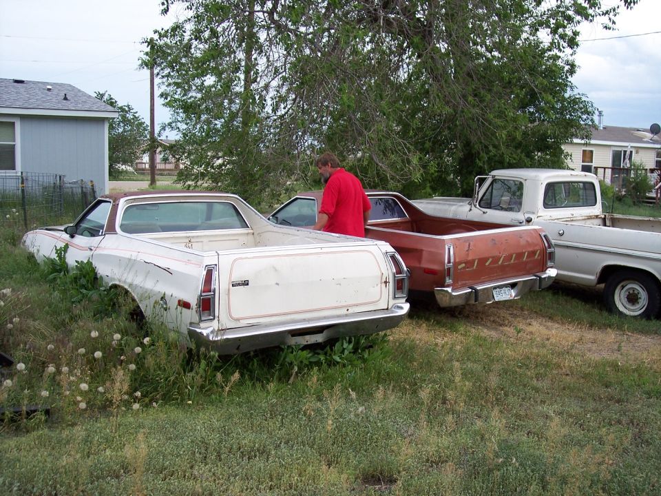 1972 Ford Ranchero parked in grass next to two other trucks
