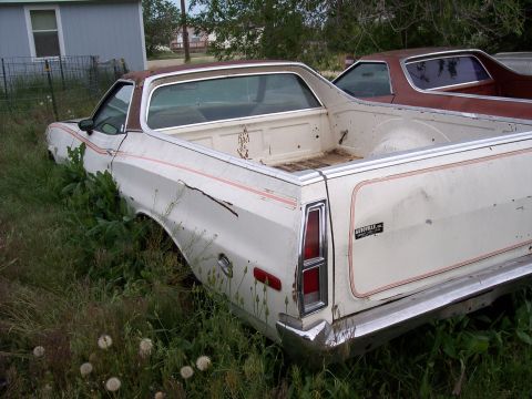 1972 Ford Ranchero - Rear view of a 1972 Ford Ranchero sitting in overgrown grass with another vehicle visible behind it.