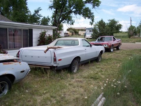 1972 Ford Ranchero - A light gray 1972 Ford Ranchero pickup truck is parked in a grassy yard next to a house, with another car behind it.