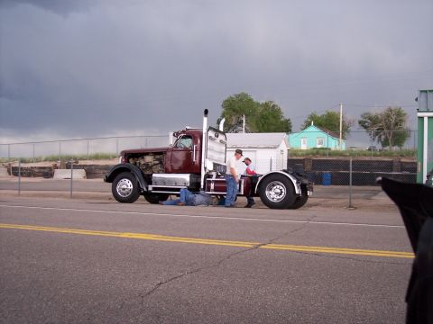 1972 Ford Ranchero - Men working on a semi-truck with its hood open on the side of the road.