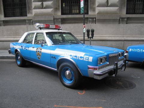 1991 Ford LTD Crown Victoria - blue and white vintage NYPD 78 Precinct sedan with roof light bar parked along a downtown curb.