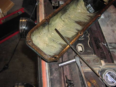 1981 Ford Bronco - Sludgy oil pan removed from engine, showing the buildup of contaminants.