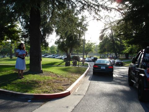 1993 Ford Taurus - A tow truck is visible on the right side of the road, with several cars driving past and parked in the background.