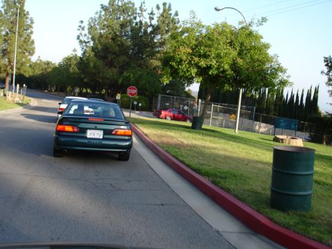 1993 Ford Taurus - A green sedan with license plate 3PBE753 is seen from behind, with another car visible ahead.