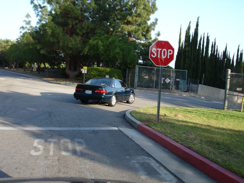 Dark 1993 Ford Taurus sedan turning right at a stop sign