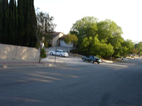 1993 Ford Taurus - A residential street scene with two cars visible, one green sedan and one white sedan.