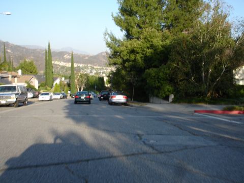 1993 Ford Taurus - A residential street scene with multiple vehicles parked along the curb under a clear sky.