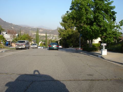 1993 Ford Taurus - Multiple vehicles are parked on a suburban street with a van and a green sedan visible.