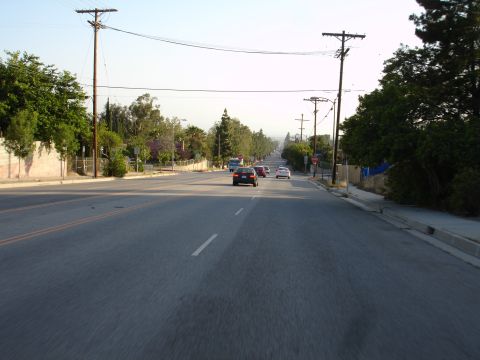 1993 Ford Taurus - A view down a suburban street with several cars driving in the same direction.