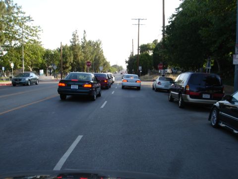 1993 Ford Taurus - A dark 1993 Ford Taurus is seen from behind while driving in traffic on a sunny day.