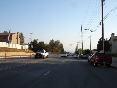 1993 Ford Taurus - Multiple vehicles are seen driving and parked on a street with utility poles and buildings in the background.
