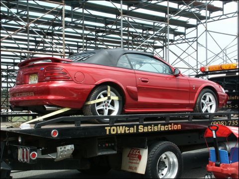 2001 Mercury Grand Marquis - A red convertible Mustang Cobra is being towed on a flatbed truck.