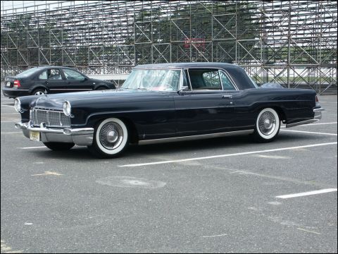 2001 Mercury Grand Marquis - A classic Lincoln Continental is parked in a lot with bleachers visible in the background.