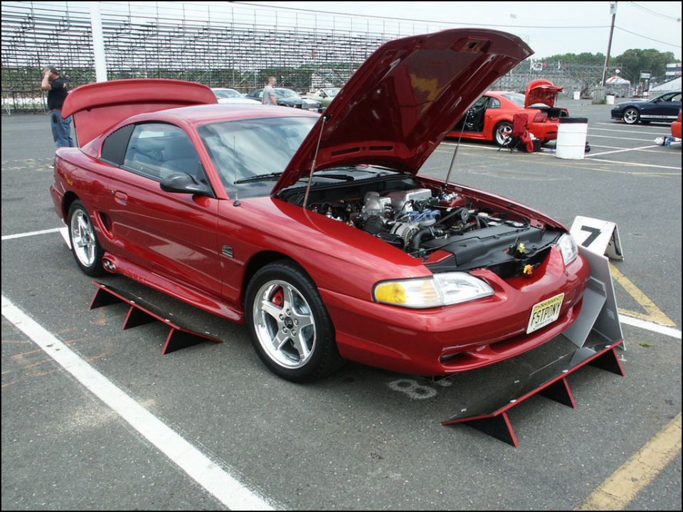 Red 1994 Ford Mustang coupe with hood open, showing engine