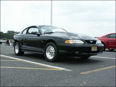 2001 Mercury Grand Marquis - This black Ford Mustang has a hood scoop and racing tires, indicating it's modified for performance.