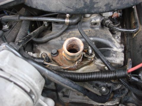 1983 Ford Bronco - reinstall the stud and the bolt and then the ground wire and then the nut. the thermastat swap is complete.
