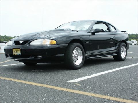 2001 Mercury Grand Marquis - This black Ford Mustang coupe features racing slicks and a prominent hood scoop, suggesting performance modifications.